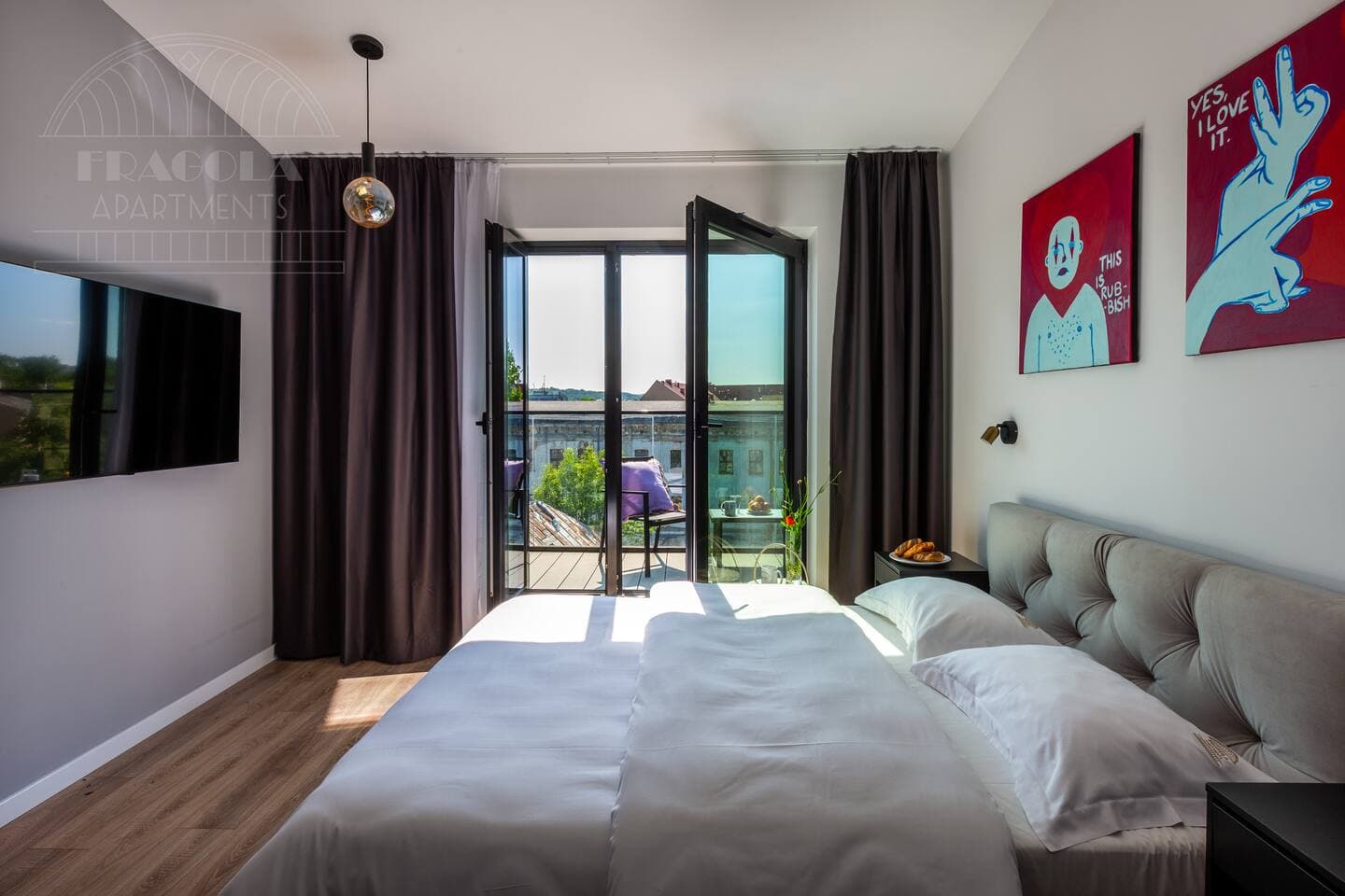 - Wake up to sunshine and fresh air in this stylish bedroom with private balcony access
- Enjoy a peaceful retreat with plush bedding, bold artwork, and plenty of natural light
- Perfect spot to sip morning coffee, unwind, and take in the views