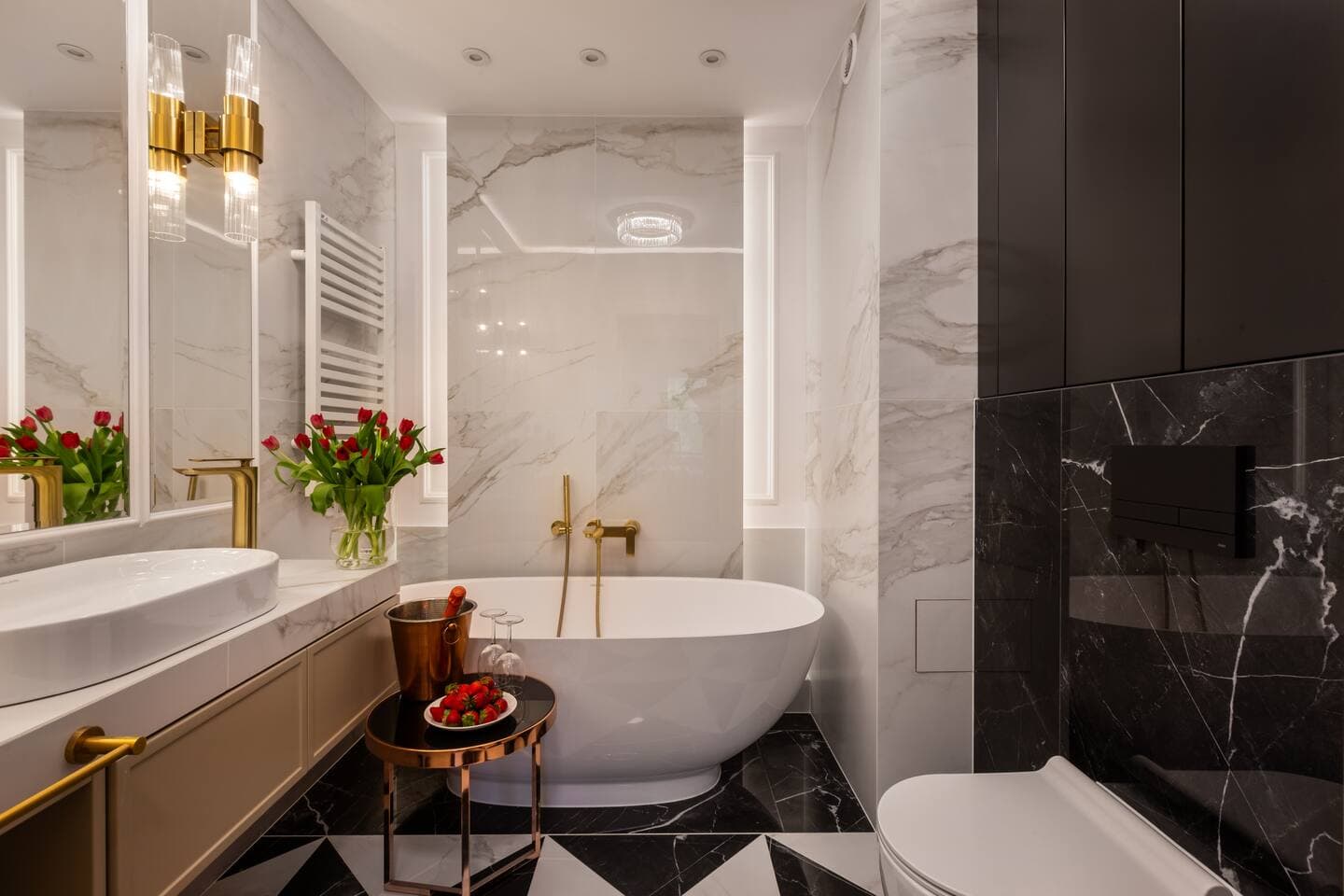 Spa-inspired bathroom w/ soaking tub, marble walls & polished gold accents