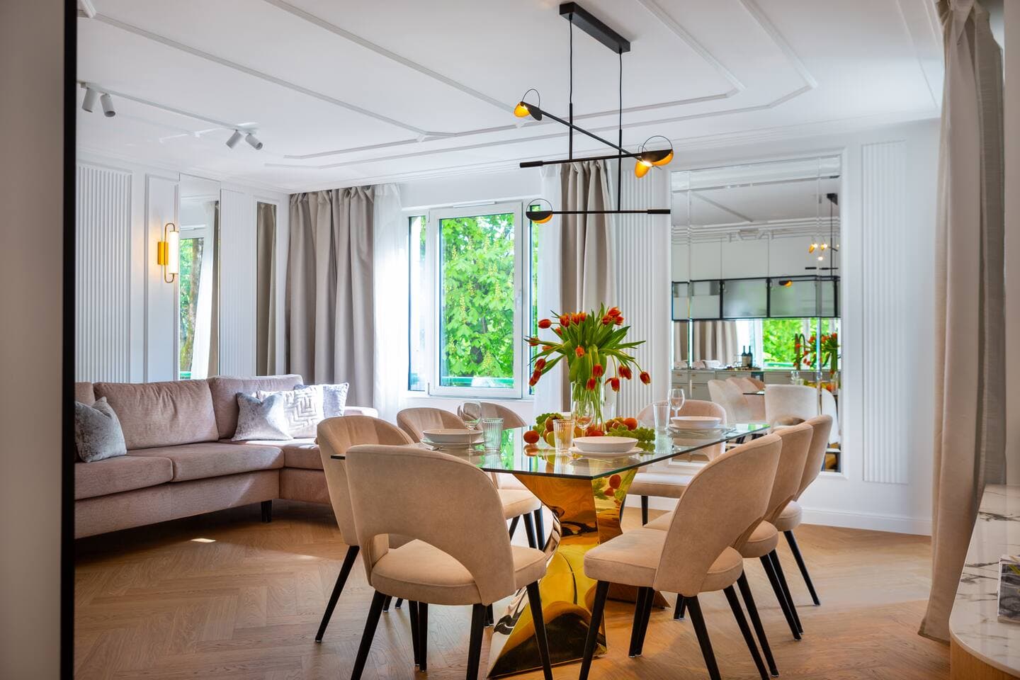 Bright open living & dining space w/ floor-to-ceiling curtains and leafy views throughout